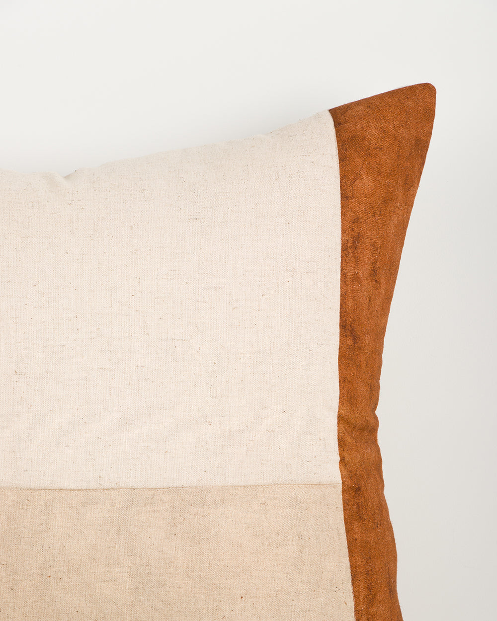 Baya Piazza Cushion in Multi, close view of a corner showing the rust panel edge and natural linen panels.