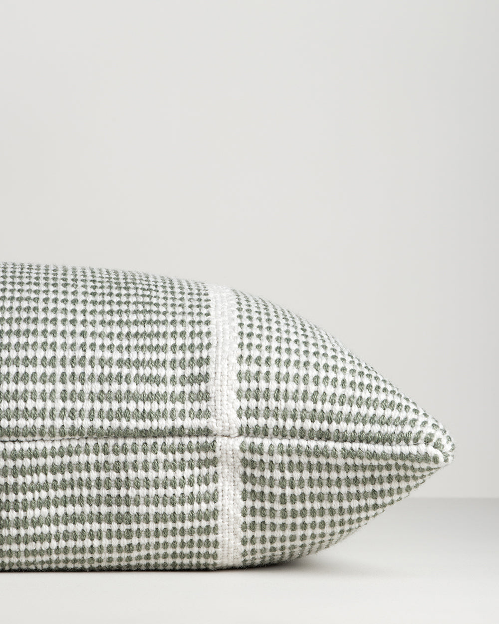 Close-up of the end seam and weave on the Baya Shore outdoor lumbar cushion in Eucalyptus