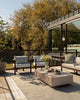 Wide lifestyle shot of the Baya Shore outdoor lumbar cushion in Eucalyptus styled on a patio setting