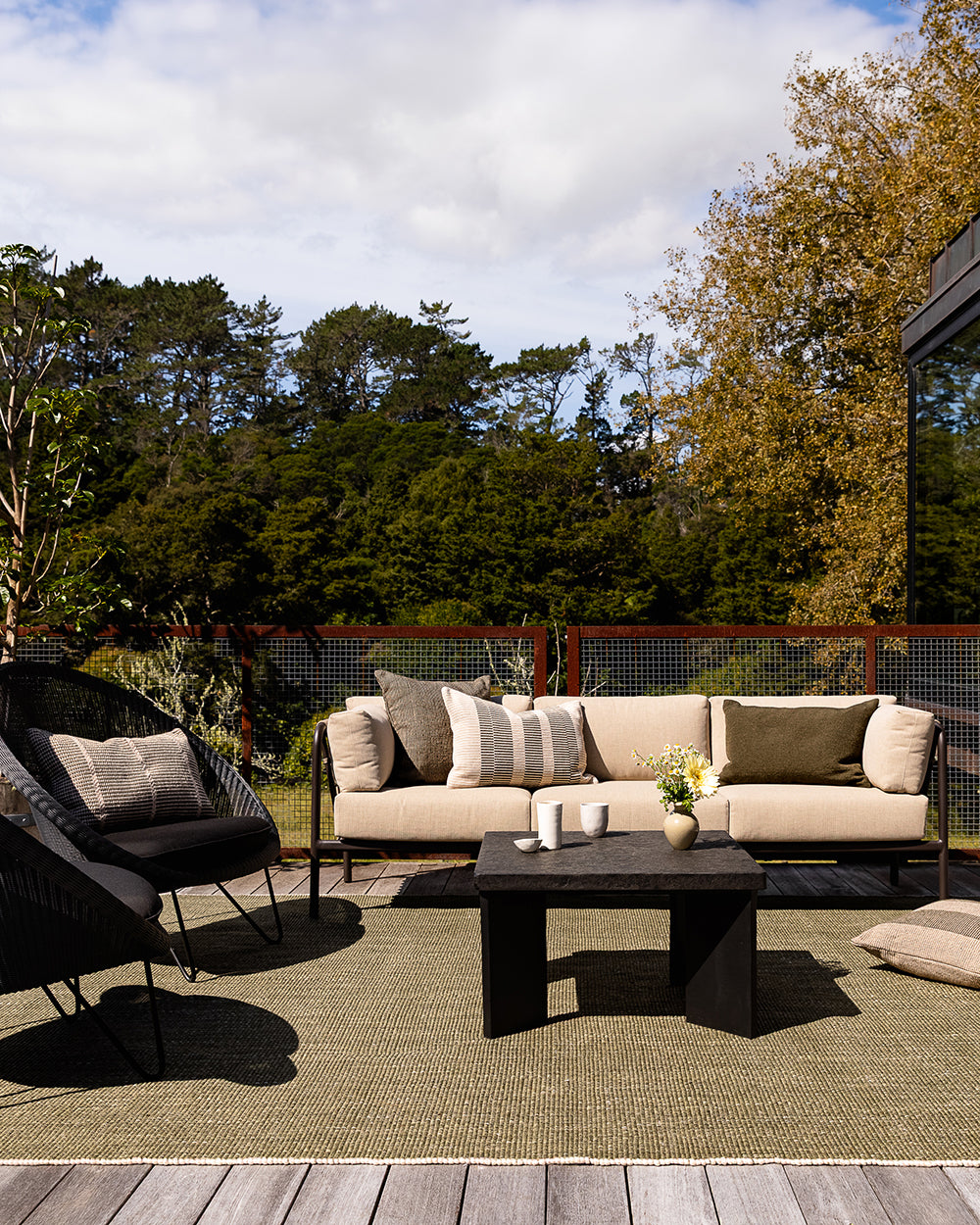 Baya Shore outdoor lumbar cushion in Mangrove styled on a black outdoor chair