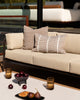 Baya Shore outdoor lumbar cushion in Tobacco styled on an outdoor sofa, with a second textured cushion in the background