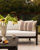 Baya Solar Outdoor Lumbar Cushion in Claret, styled on an outdoor sofa.