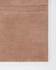 Baya Strata NZ wool floor rug in Clay, close view of a corner showing the pile and a horizontal ridged line.