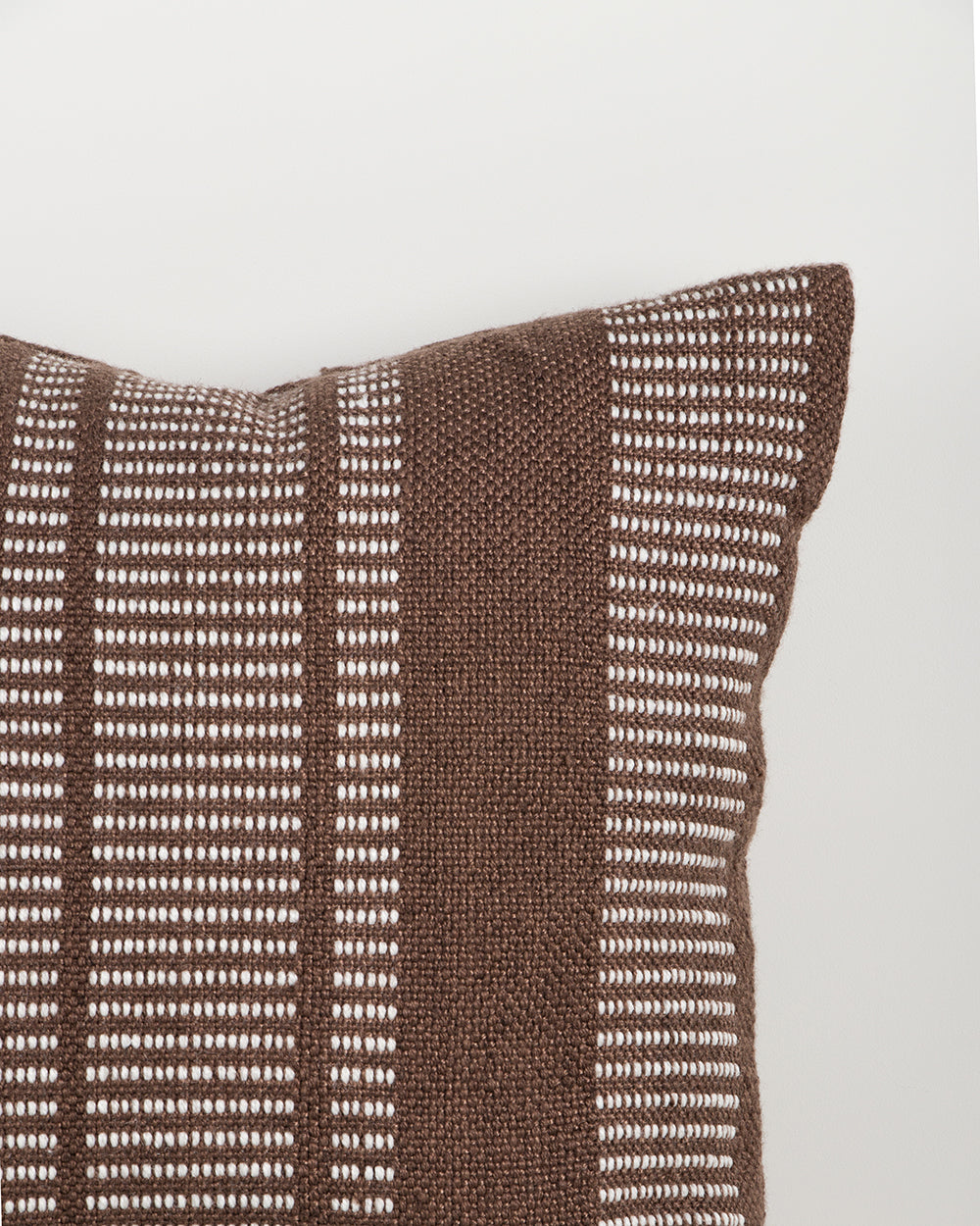 Baya Swell Outdoor Cushion in Chocolate, close view of the woven texture in off-white and chocolate-brown tones.