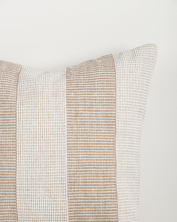 Close-up of the Baya Tide Outdoor Cushion in Almond, showing the woven linework stripe and piped edge.