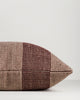 Side view of the Baya Tide Outdoor Cushion in Claret, showing the handwoven stripe wrapping the cushion edge.