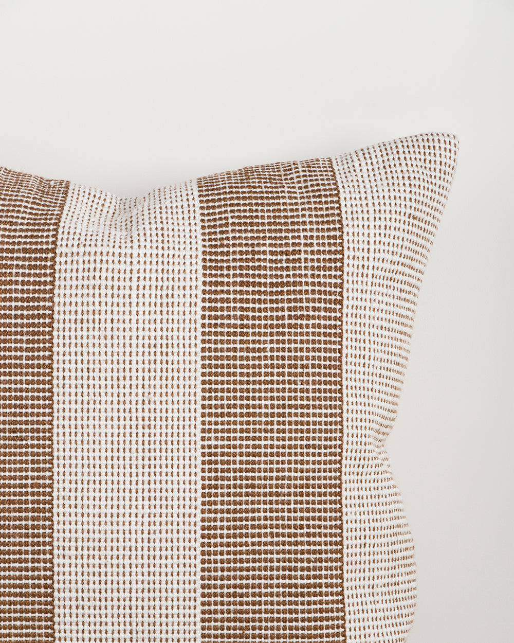 Close-up of the Baya Tide Outdoor Cushion in Tobacco, showing the woven stripe texture and piped edge.