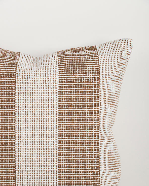 Close-up of the Baya Tide Outdoor Cushion in Tobacco, showing the woven stripe texture and piped edge.