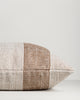 Side view of the Baya Tide Outdoor Cushion in Tobacco, showing the handwoven stripe wrapping the cushion edge.