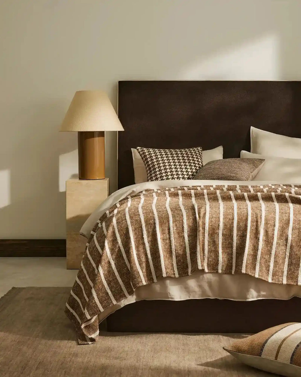 A stylish bedroom setting featuring Weavew Home decor in warm brown shades