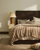 A stylish bedroom setting featuring Weavew Home decor in warm brown shades