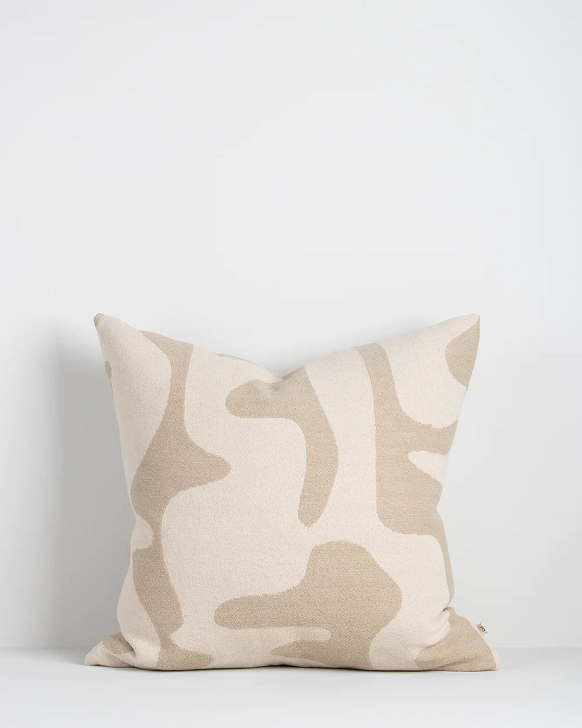 Beige toned cushion featuring organic abstract shapes in natural tones
