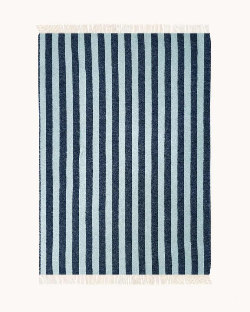 A full image of a throw blanket, spread to see the full pattern of dark blue and ice blue stripes. 