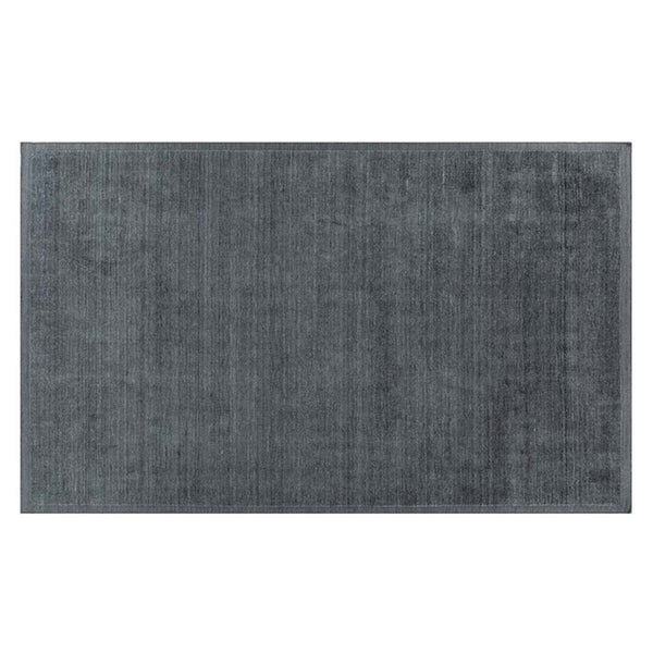 Full view of a handmade wool rug in a neutral, muted blue shade, with an indented border adding interest. 