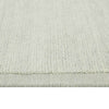 Close up of the weave of a handmade, 100% wool floor rug by Soren Liv NZ and Globe West, in subtle shades of light blue and green, shades of seafoam. The edge is indented, lending interest to the rug. 