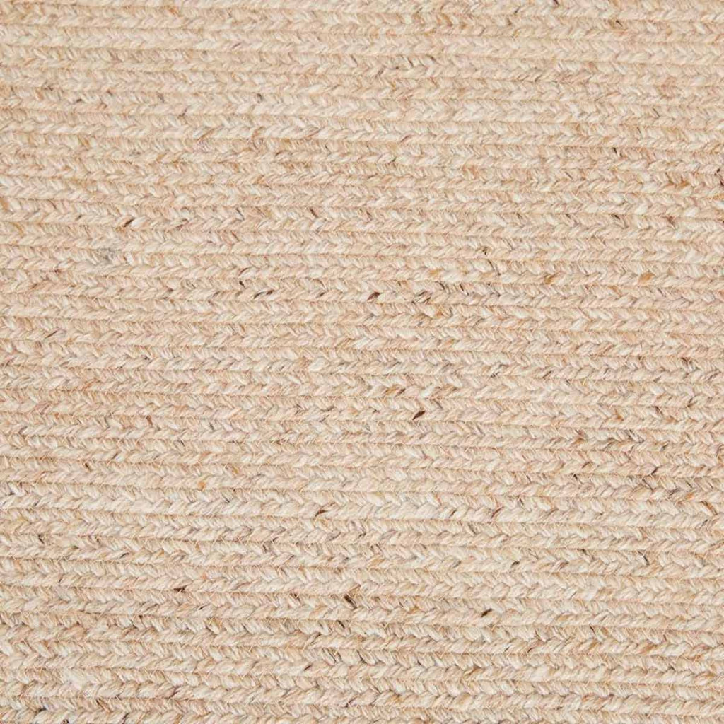 A close up of a braided rug by Globe West and Soren Liv NZ in natural beige tones, perfect for outdoors or transition spaces. 