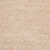 A close up of a braided rug by Globe West and Soren Liv NZ in natural beige tones, perfect for outdoors or transition spaces. 