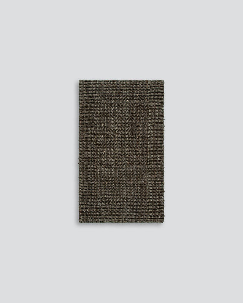 A full image of a textural dark toned entrance mat, handmade with natural jute fibres by Baya