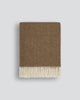 Brown wool blanket in a micro herringbone pattern with fringe on a light grey background
