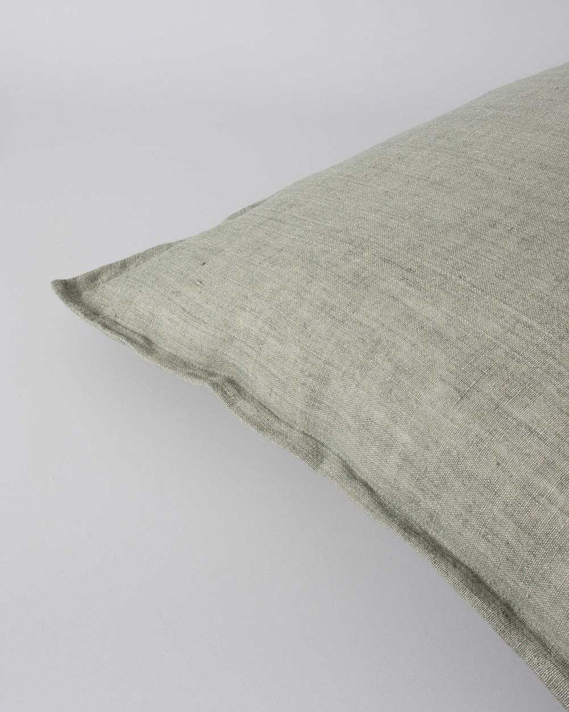 Corner of the Baya square linen cushion in colour sage green, showing flange detail