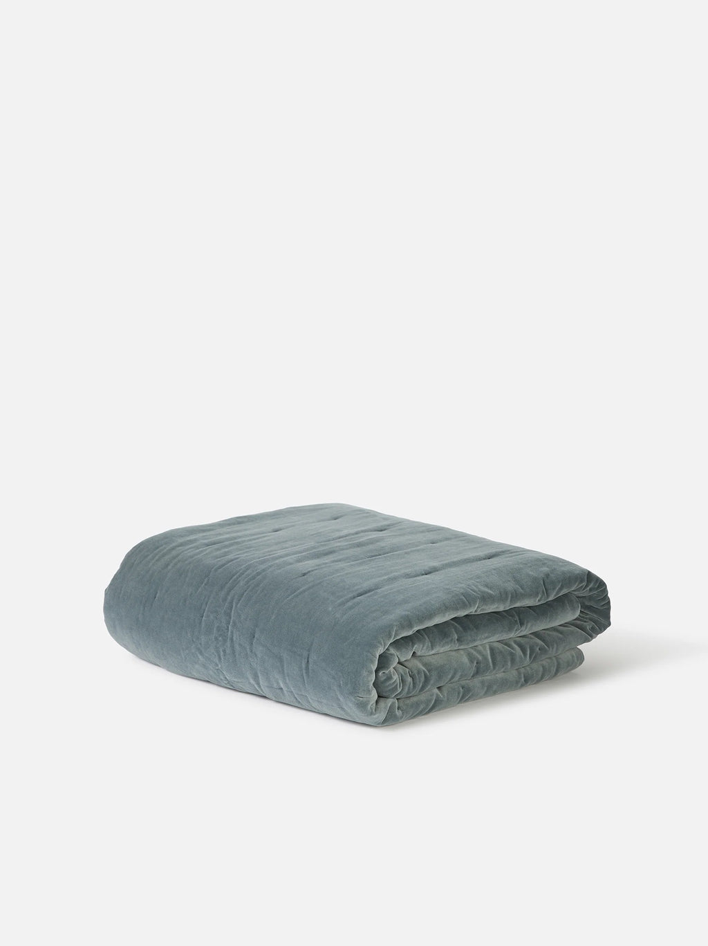 Città Cotton Velvet Quilt in Cod, a blue-grey quilt folded on a plain background