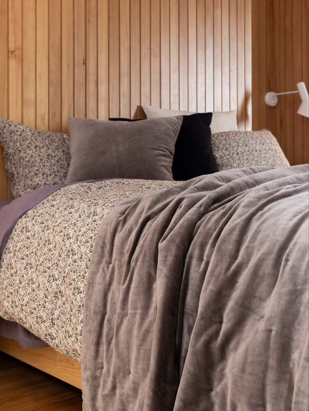 Città Cotton Velvet Quilt in Doe, draped over the end of a bed in a styled bedroom.