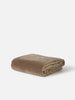 Città Cotton Velvet Quilt in Doe, a warm taupe quilt folded on a plain background