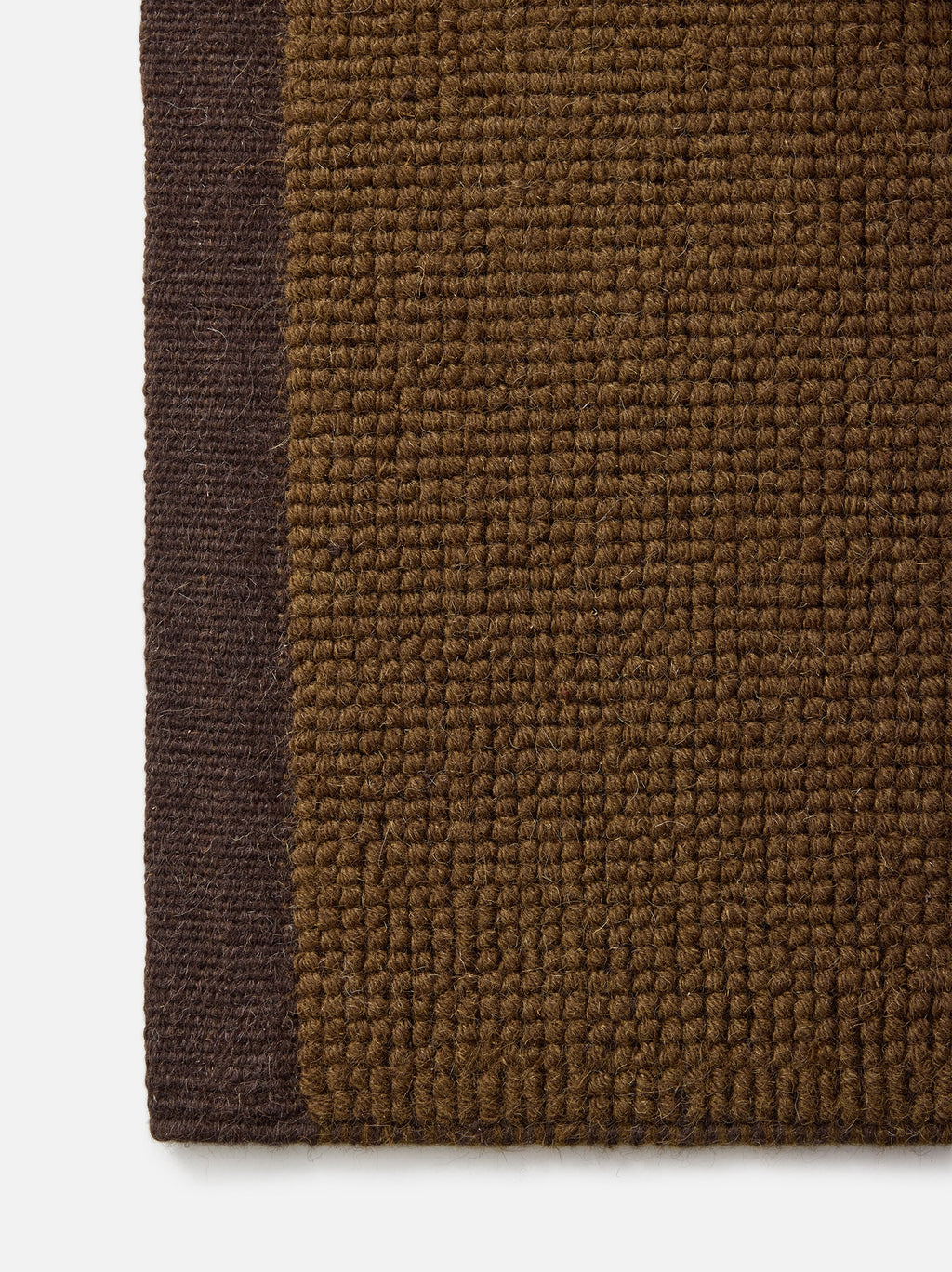 Città Joni Wool Mat in Kelp/Umber, close-up of the flat-woven texture and trim edge.