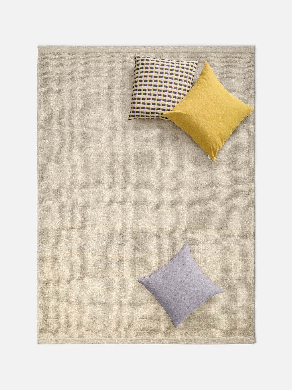 Città Joni Wool Mat in Oatmeal, overhead view styled in a living space.