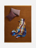Città Joni Wool Mat in Orange Peel/Saffron, overhead view styled with cushions and a throw.