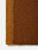 Città Joni Wool Mat in Orange Peel/Saffron, close view of the popcorn-style woven texture.
