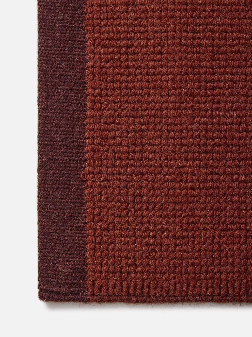 Città Joni Wool Mat in Paprika/Mulberry, close view of the popcorn-style woven texture.