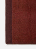 Città Joni Wool Mat in Paprika/Mulberry, close view of the popcorn-style woven texture.