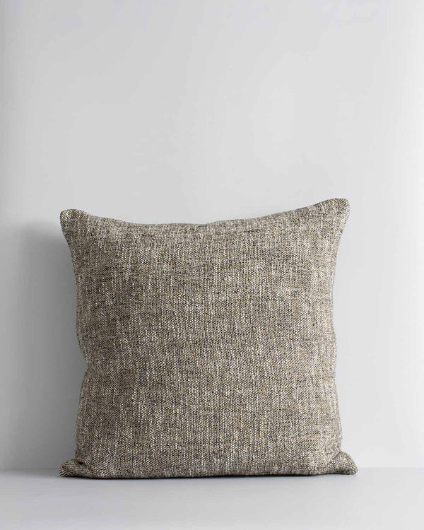 A textured woven cushion in shades of pebble brown and ercu, by Baya