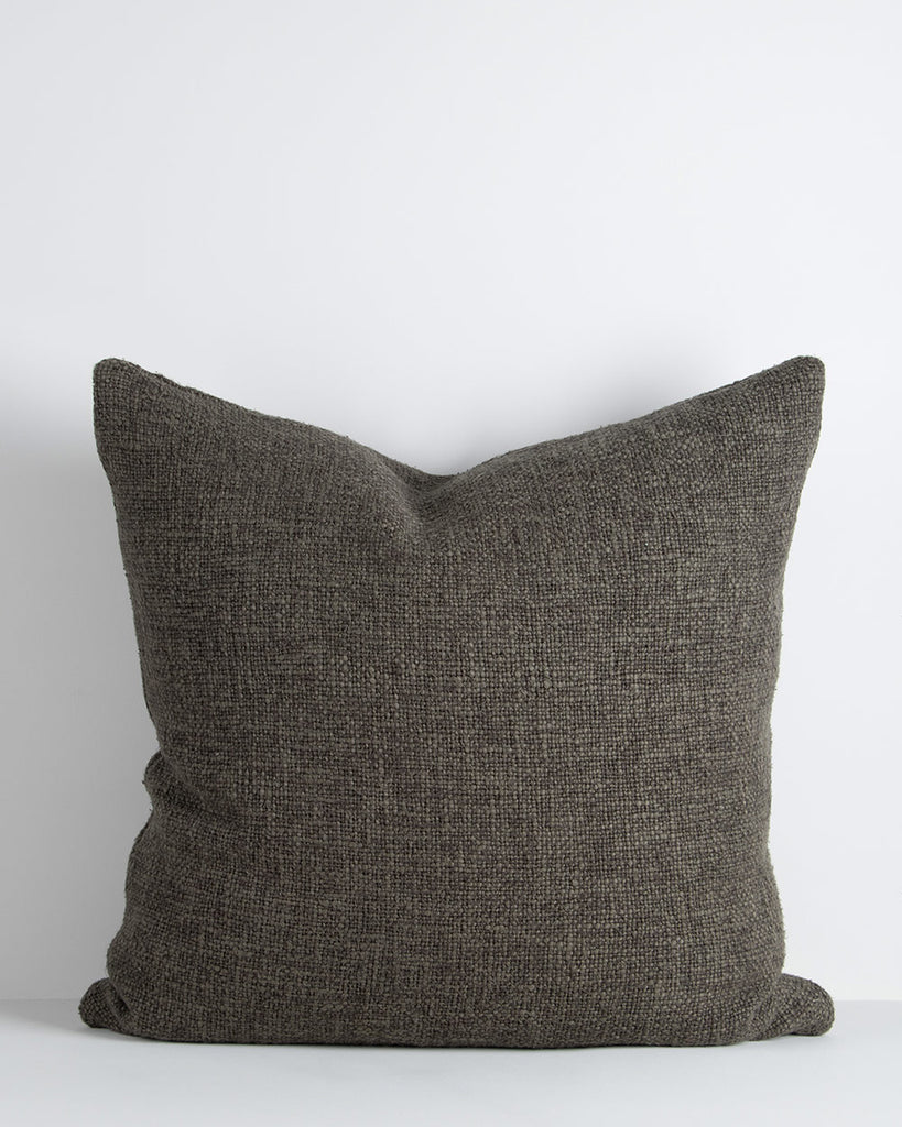 A textural large cushion with a soft, large-thread weave in shades of deep green. By Baya
