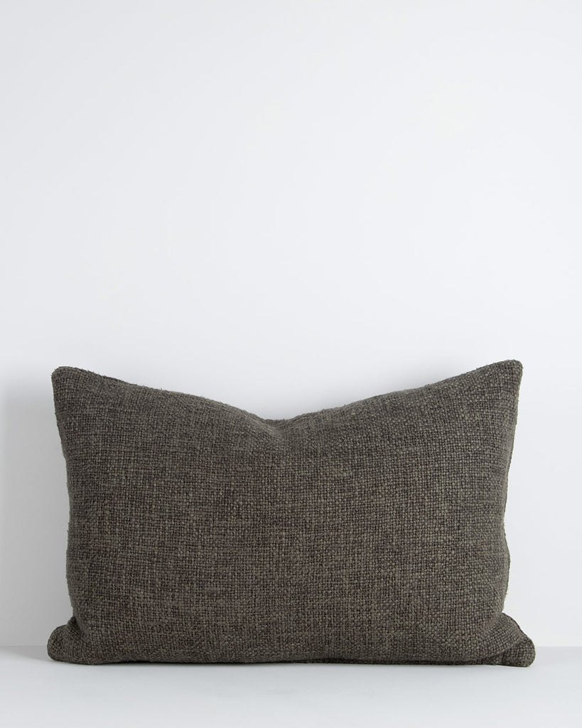 A textural lumbar cushion with a soft, large-thread weave in shades of deep green. By Baya