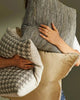 Weave Home cushions including the 'Vista Mineral', a textural weave in rock-inspired greys and browns, held by a woman