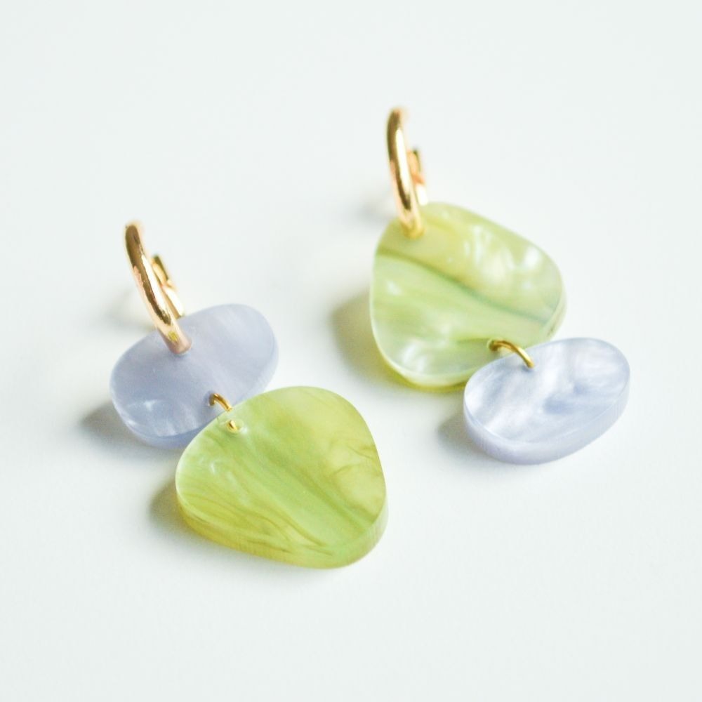 A gorgeous pair of gold hoops with organically shaped acrylic charms in iridescent light blue and marbled sage green.