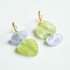 A gorgeous pair of gold hoops with organically shaped acrylic charms in iridescent light blue and marbled sage green.