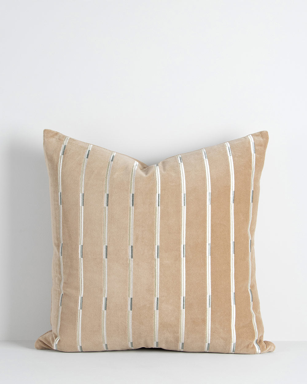 A soft velvety textural cushion with stripes in shades of soft light brown and beige. By Baya
