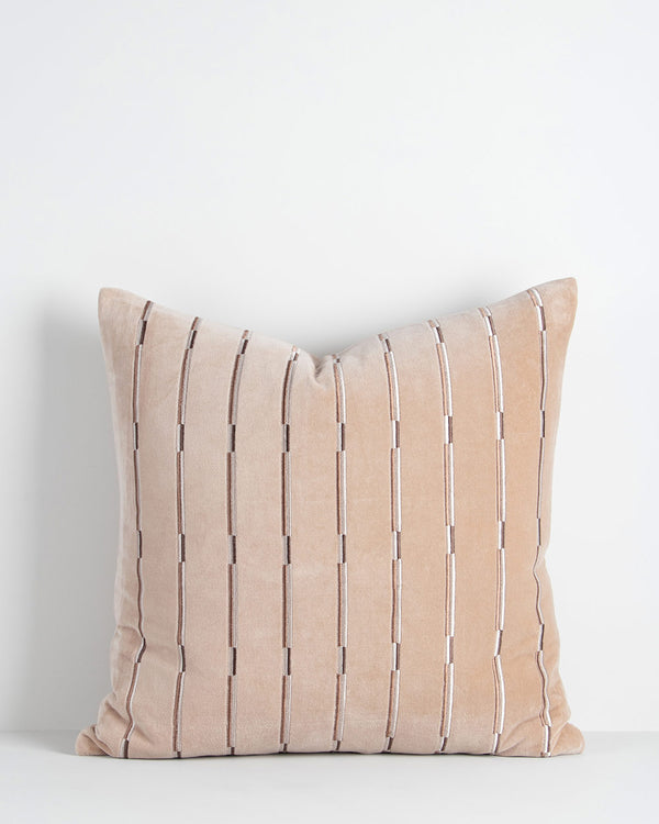 A soft velvety textural cushion with stripes in shades of soft creamy pink and beige. By Baya