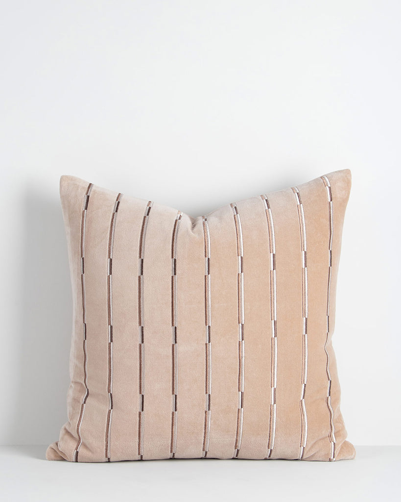 A soft velvety textural cushion with stripes in shades of soft creamy pink and beige. By Baya