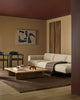 Modern living room with a beige sofa, wooden coffee table, large brown wool throw and brown rug