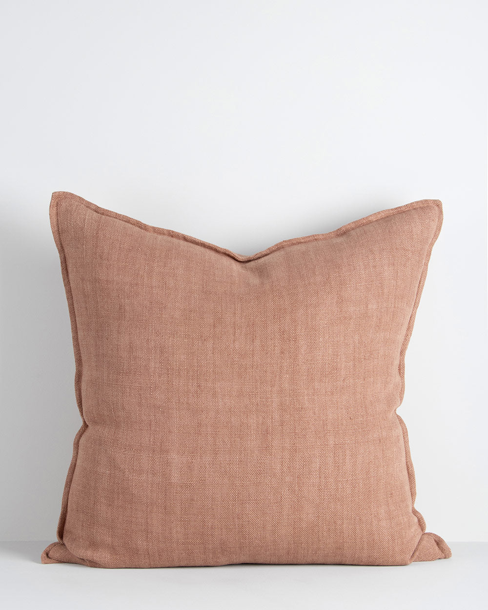 A large cushion in a soft but textural linen with a flange edge in clay red-brown. By Baya