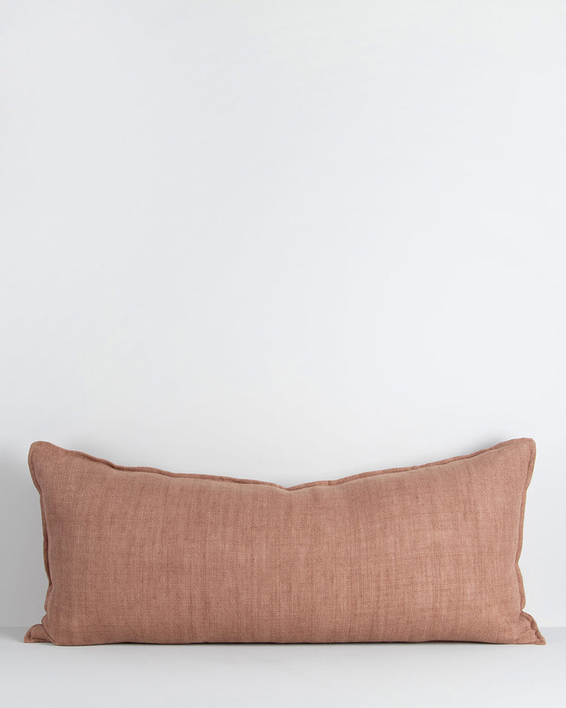 A long lumbar cushion in a soft but textural linen with a flange edge in clay red-brown. By Baya