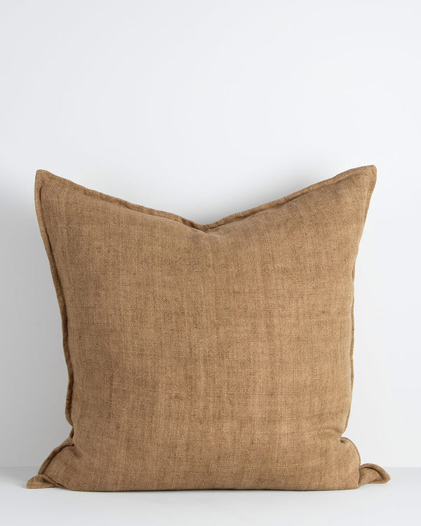 A large cushion in a soft but textural linen with a flange edge in caramel brown. By Baya