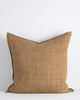 A large cushion in a soft but textural linen with a flange edge in caramel brown. By Baya