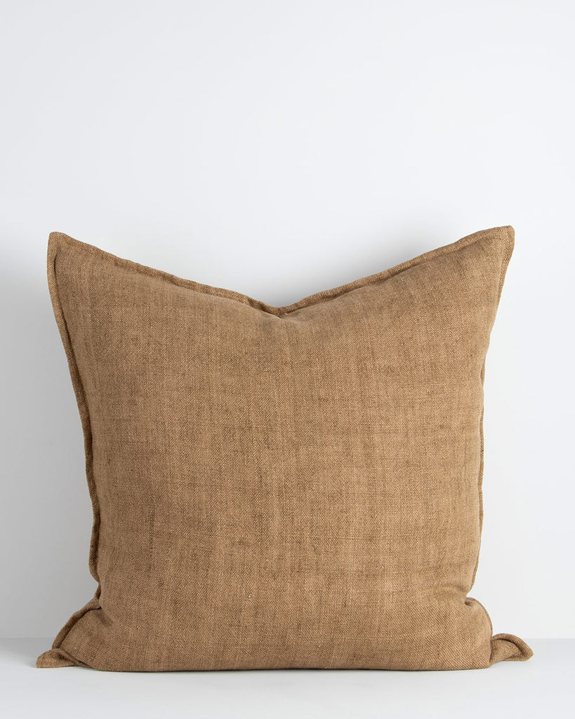 A large cushion in a soft but textural linen with a flange edge in caramel brown. By Baya