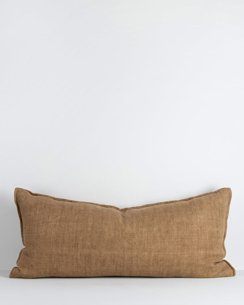 A long lumbar cushion in a soft but textural linen with a flange edge in caramel brown. By Baya
