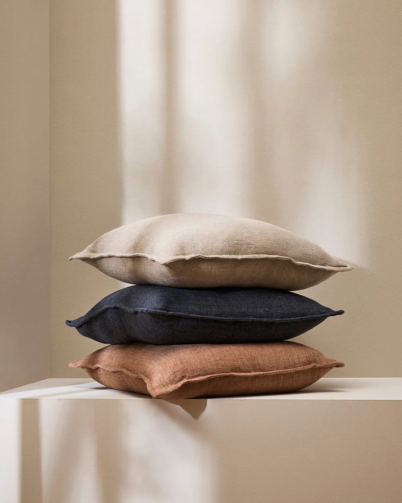 A stack of Baya 100% linen cushions in three on trend colourways